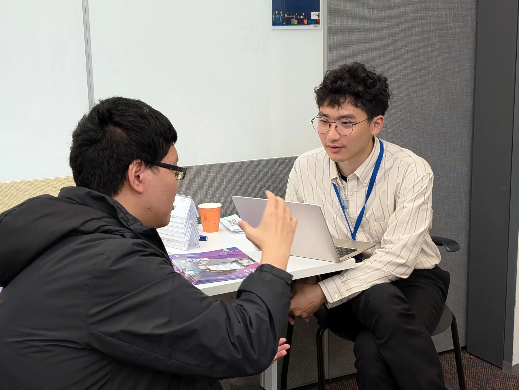 企業の現場で社員と 1 対 1 で話し合うコンサルタント